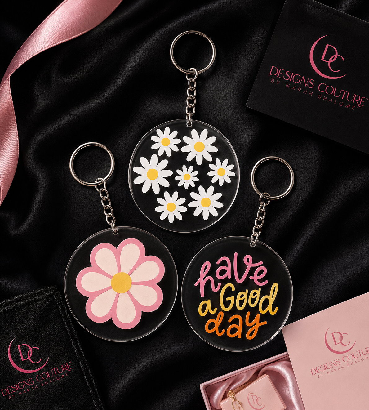 Acrylic flower and phrase keychains styled on black satin